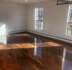 an empty room with large windows and hard wood flooring in the center is shown