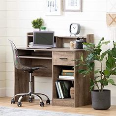 a computer desk with a plant on top of it