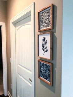 three framed pictures hang on the wall next to a door in a home's entryway