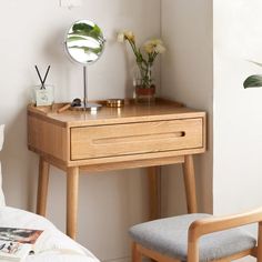 a small wooden desk with a mirror on it and a chair in front of it