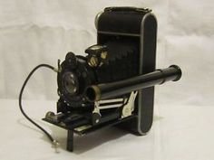 an old fashioned camera sitting on top of a stand