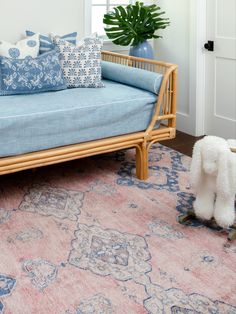 a living room with a couch, rug and potted plant