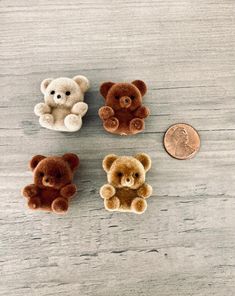 four small teddy bears sitting next to a penny