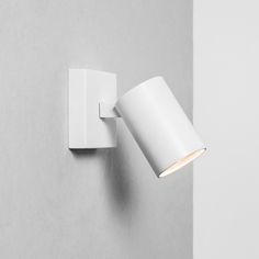 a white wall light mounted on the side of a gray wall