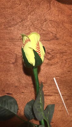 a yellow flower with a baseball on it