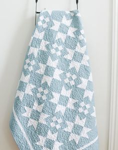 a blue and white quilt hanging from a hook