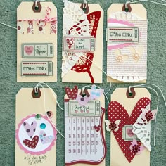 four tags with different designs on them hanging from clothes pins and twine strings in the shape of hearts