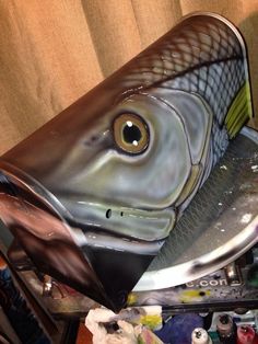 a fish shaped cake sitting on top of a metal pan covered in chocolate frosting