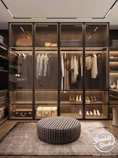 a walk in closet with lots of clothes and shoes on the shelves, along with a footstool