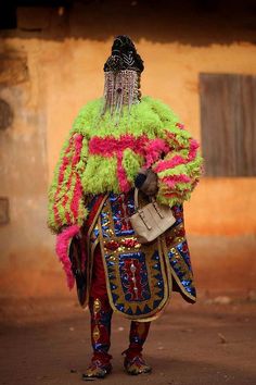 a man dressed in colorful clothing standing on the street