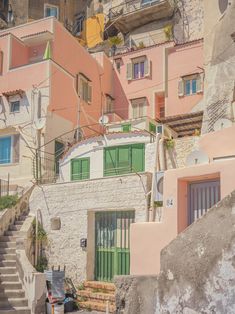 an old building with green shutters and stairs