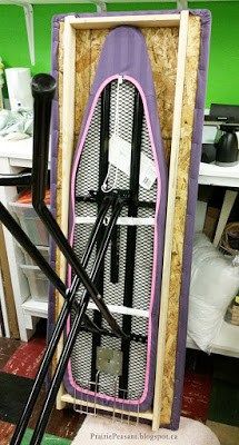 a purple and white surfboard sitting on top of a wooden stand in a room