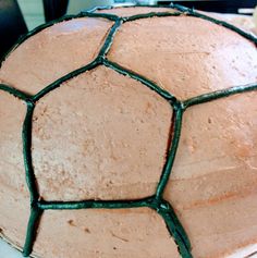 a close up of a cake with frosting and green icing on the top