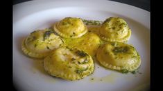 some ravioli on a white plate with pesto