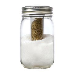 a glass jar filled with white sand and sea salt