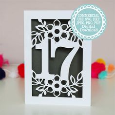 a card with the number seventy on it and some pom poms around it