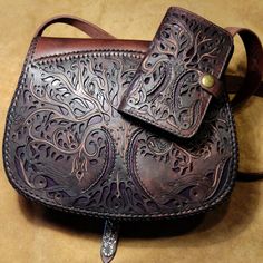 a brown leather purse sitting on top of a table next to a cell phone holder