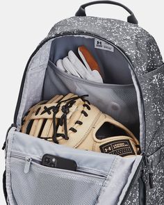 a backpack filled with baseball equipment sitting on top of a white floor