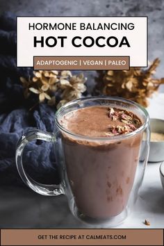 a glass mug filled with hot cocoa on top of a table