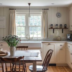 a kitchen with a table and chairs in front of a window that is open to the outside