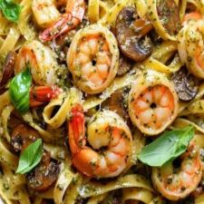 pasta with shrimp, mushrooms and basil in a white bowl