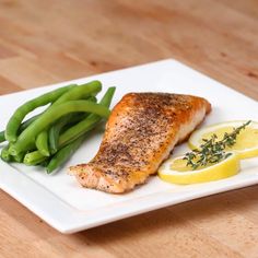 a white plate topped with fish and green beans