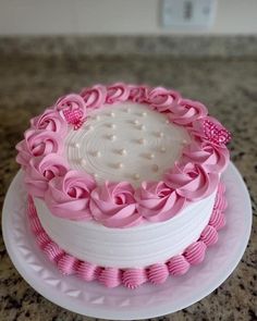 a pink and white cake sitting on top of a counter