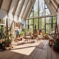 a room filled with lots of furniture and paintings on the wall next to large windows