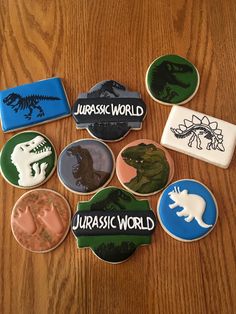 some cookies that are on top of a table with words and dinosaurs in them,