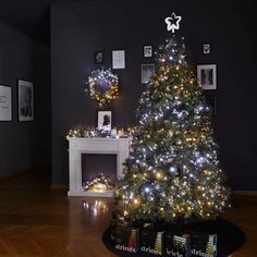 a lit christmas tree in a living room with pictures on the wall and around it