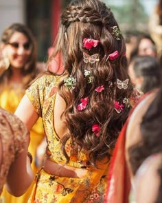 the back of a woman's head with flowers in her hair and other people around