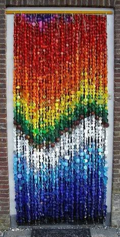 the door is made out of plastic bottle caps and has a rainbow painted on it