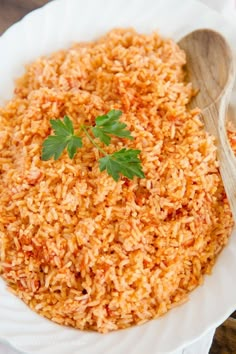 a white bowl filled with brown rice and garnished with parsley on top