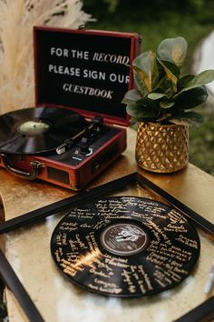 a record player sitting on top of a table next to a potted plant