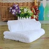 two white towels sitting on top of a wooden table next to bottles and vases