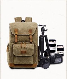 a backpack, camera and tripod sitting next to each other