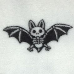 a black and white image of a bat with skull on it's back side