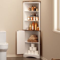 a white toilet sitting next to a shelf filled with lots of bottles and soaps