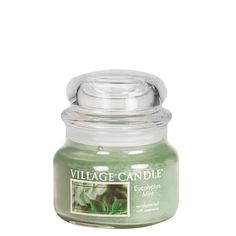 a small jar filled with green candles