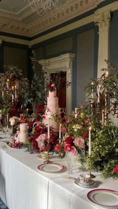 the table is set with many different types of cakes and flowers on it, along with candles