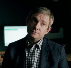 a man sitting in front of two computer monitors