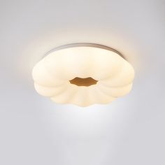 a ceiling light that is on in a room with white walls and flooring,