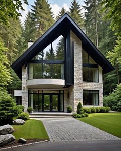 a very nice looking house in the middle of some trees and grass with lots of windows