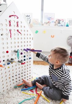 a toddler playing with peg board toys on the floor