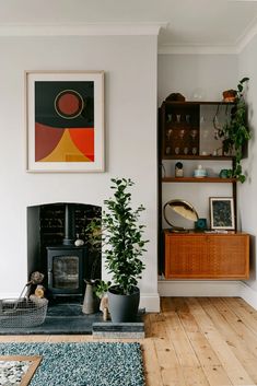 a living room filled with furniture and a fire place in the middle of a wooden floor