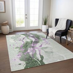 a living room area with a rug, chair and potted plant on the floor