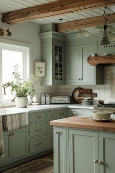 a kitchen filled with lots of green cupboards and counter top next to a window