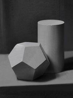 two white vases sitting next to each other on top of a gray countertop