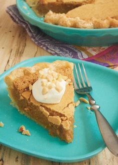 a piece of pie on a blue plate with a fork next to it and another slice in the background