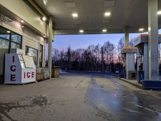 an empty gas station at dusk with no one in the car or waiting for their turn